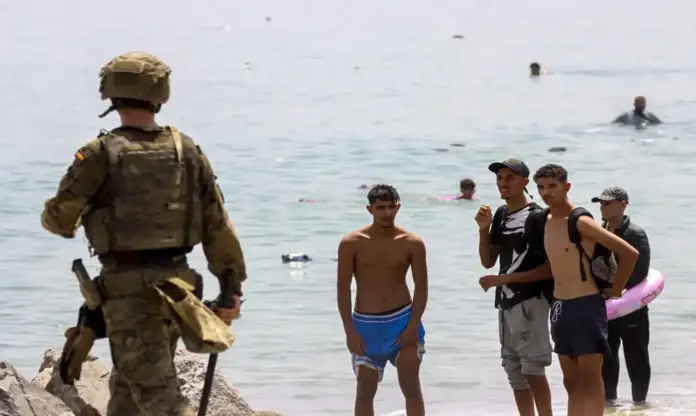 Invasión Ceuta, Ceuta FOTOGRAFÍA. CIUDAD AUTÓNOMA DE CEUTA (ESPAÑA), 31 DE JULIO DE 2026. El Ejército, la Policía y Guardia Civil desplegados en Ceuta el tiempo que sea necesario. El Ejército español desplegado en la frontera del Tarajal (Castillejos) con Ceuta (España) ante la atenta mirada de los inmigrantes ilegales marroquíes este viernes, 31 de julio de 2026, tercer día de la invasión marroquí de Ceuta, más de 50.000 invasores, según datos de fuentes gubernamentales españolas este viernes en rueda de prensa cuando se siga registrando nuevos asaltos. El Gobierno de España dice que al menos la mitad de los 50.000 invasores ya ha retornado voluntariamente a Castillejos (Marruecos) al tiempo que anuncia reforma de la Ley de Extranjería, sin contar con los votos suficientes para lograr su aprobación, para poder hacer las repatriación masivas de ilegales; el mismo Ejecutivo del socialista y migracionista Pedro Sánchez Pérez-Castejón que tiene en la actualidad un proceso de regularización masiva de más de 1.000.000 de ilegales en el país desde 2021. Efe