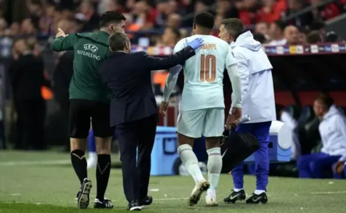 Kylian Mbappé, delantero del Real Madrid, sufre una hiperextensión de la cápsula posterior de la rodilla izquierda. EFE FOTOGRAFÍA. ESMIRNA, 25 DE SEPTIEMBRE DE 2026. Estadio de la ciudad de Esmirna (Izmir), Turquía (durante el encuentro correspondiente a la primera jornada de la UEFA Nations League entre las selecciones de Turquía y Francia). La captura muestra el momento exacto en el que Kylian Mbappé abandona el terreno de juego cojeando y visiblemente dolorido en el minuto 59 del encuentro. Está siendo acompañado y consolado por el nuevo seleccionador de Francia, Zinedine Zidane, y los asistentes del cuerpo médico galo, instantes después de haberse lastimado la articulación izquierda en el apoyo de la jugada del gol que le dio el triunfo a su país (0-1). EFE