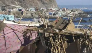 FOTOGRAFÍA. CEUTA, 26 DE SEPTIEMBRE DE 2026. Un extenso e improvisado campamento de chabolas levantado por miles de inmigrantes ilegales de origen marroquí y subsahariano abarrota por completo la zona rocosa y el litoral de la playa del Trampolín. En primer plano, se observa la precaria estructura de un habitáculo clandestino construido a base de cartones, maderas, cañas y plásticos de diversos colores, rematada con un peluche infantil como parte del entorno de asentamiento informal. Al fondo, a faldas de la ladera costera, se agolpan decenas de tiendas de campaña donde pernoctan los ciudadanos extranjeros en situación irregular, con presencia visible de personas moviéndose por los accesos y un buque mercante navegando al fondo en aguas del Estrecho. Esta ocupación de los espacios públicos refleja la grave crisis de seguridad y vecinal que sufre la ciudad autónoma, cumpliéndose hoy exactamente 58 días desde el inicio de la entrada masiva sin precedentes del pasado jueves 30 de julio de 2026. EFE