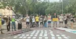 FOTOGRAFÍA. ALGEMESÍ (ESPAÑA), 20 DE SEPTIEMBRE DE 2026. Un grupo integrado por unas quince personas pertenecientes a la plataforma antitaurina se congrega en un espacio público empedrado de Algemesí durante la jornada de protesta de este domingo. Los manifestantes se disponen en fila portando pancartas y carteles informativos en los que se leen lemas como "No es cultura, es tortura" y "Subvenciones taurinas para educación pública, bomberos y sanidad". Algunos de los integrantes de la cabecera portan instrumentos musicales de viento-metal y de percusión. Frente a ellos, extendidas ordenadamente sobre el pavimento, se aprecian decenas de cartulinas de color blanco alineadas en hileras simétricas que recogen datos y mensajes explicativos dirigidos a los ciudadanos del municipio. Lasvocesdelpueblo (Ñ Pueblo)