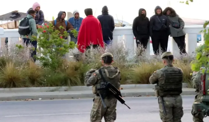 FOTOGRAFÍA. CEUTA (ESPAÑA), 16 DE SEPTIEMBRE DE 2026. Imagen de varios miembros del Ejército frente a unos inmigrantes de la invasión de Ceuta. EFE 