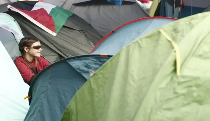 Acampada ilegal en Puerta del Sol, El PSOE concentra un masivo arsenal de viviendas en propiedad en plena crisis del alquiler (1) FOTOGRAFÍA. MADRID, 06 DE OCTUBRE DE 2026. Una joven ultraizquierdista protegida con gafas de sol sonríe desde el interior de una de las cientos de tiendas de campaña instaladas de manera ilícita por colectivos de la ultraizquierda en pleno corazón de la Puerta del Sol de Madrid. Sobre las estructuras de lona destaca de forma nítida una bandera de Palestina, evidenciando la mezcla de consignas ideológicas y la instrumentalización de la crisis de la vivienda por parte de grupos radicales. Esta protesta callejera se escenifica en un momento de enorme tensión política, mientras los datos del Congreso desvelan la opulencia inmobiliaria de la bancada del PSOE, donde el 40 % de sus diputados (48 parlamentarios) poseen al menos dos casas en propiedad, incluyendo a dirigentes destacados como la portavoz del partido Montse Mínguez o el portavoz del grupo parlamentario Patxi López, quienes declaran tres inmuebles residenciales propios. EFE.