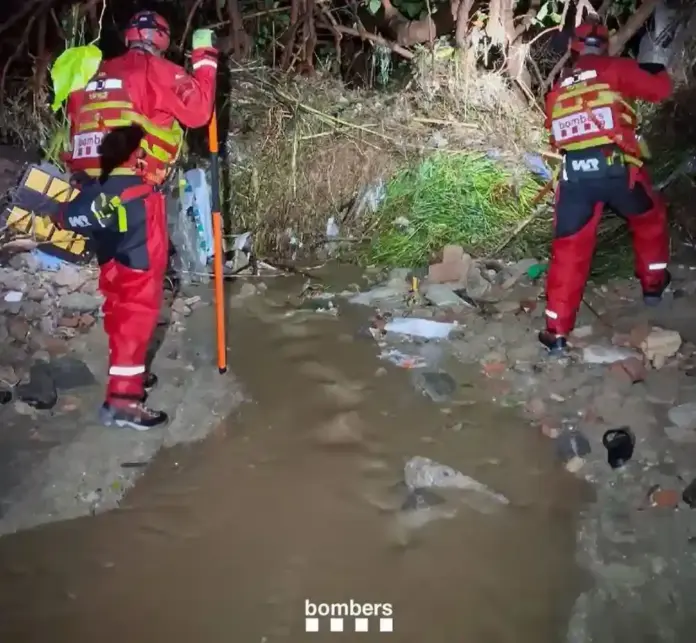 El temporal «Adam» azota Cataluña con inundaciones, rescates extremos y el del río Besòs FOTOGRAFÍA. CABRERA DE MAR, 18 DE OCTUBRE DE 2026. La instantánea capturada por los servicios de emergencias ilustra el minucioso e ininterrumpido dispositivo de rastreo desplegado en el cauce de la riera de Cabrera de Mar, completamente desbordada tras la brutal descarga de lluvia torrencial acumulada por el temporal «Adam». En la imagen se puede observar a los efectivos de los Bomberos de la Generalitat de Catalunya trabajando sobre el terreno enfangado y resbaladizo junto al canal de agua, equipados con cascos, linternas de alta potencia y trajes técnicos de rescate. Los especialistas inspeccionan palmo a palmo las márgenes del torrente acumulado de cañas, maleza y detritos arrastrados por la riada. La fotografía plasma las tareas de rastreo nocturno y de madrugada subrayando el crítico mensaje emitido por el cuerpo a través de la red social X: «Por lo que respecta a la búsqueda de una persona arrastrada por la riera en Cabrera de Mar, durante toda la noche y madrugada Bomberos de Cataluña hemos continuado la búsqueda, sin novedades. Mantenemos el dispositivo con 9 dotaciones, conjuntamente con Policía Local, Mossos d'Esquadra y Salvamento Marítimo». El operativo especial se enmarca en una jornada de colapso meteorológico en el que los bomberos han atendido 89 avisos, rescatado a conductores atrapados en balsas de agua de la autovía A-2 y evacuado de urgencia a personas vulnerables en Sant Esteve Sesrovires ante las inundaciones generalizadas del litoral y prelitoral central. Bomberos de la Generalidad de Cataluña/Lasvocesdelpueblo (Ñ Pueblo).