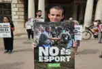 FOTOGRAFÍA. VALENCIA, 07 DE OCTUBRE DE 2026. Una hilera compacta de activistas de la Plataforma Defensa Animal se concentra de forma pacífica y rigurosa en la plaza del Ayuntamiento de València, sosteniendo pancartas con lemas explícitos que exigen la total abolición del tradicional tiro y arrastre. En primer plano, el activista y autor del artículo, Diego Nevado Martínez, sostiene con firmeza un cartel de luto y denuncia, mostrando un rostro de profunda indignación frente al consistorio. En su testimonio directo, Nevado recalca que participó en esta acción colectiva en nombre de la entidad que representa para alzar la voz por los indefensos caballos que sufren un ambiente hostil, soportando una barbaridad de peso a la fuerza entre gritos de un público sádico. La imagen captura la soledad y la persistencia de un activismo coherente y voluntario que lucha contra el supremacismo humano y la sumisión de los animales como meros objetos de entretenimiento, evidenciando de fondo la flagrante y criticada ausencia de colectivos como València Animal Save o la Coordinadora Animalista de la Comunidad Valenciana, a los que el autor acusa de cinismo, hipocresía y de buscar únicamente un baño de masas en lugar de arrimar el hombro en la lucha diaria por la liberación animal. Lasvocesdelpueblo (Ñ Pueblo)