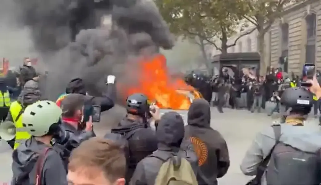 FOTOGRAFÍA. PARÍS, 19 DE OCTUBRE DE 2026. Un grupo de manifestantes encapuchados de ultraizquierda arroja objetos contundentes contra una línea de agentes de las fuerzas del orden rodeados de humo de gases lacrimógenos y fuegos provocados en la vía pública. Lasvocesdelpueblo (Ñ Pueblo)