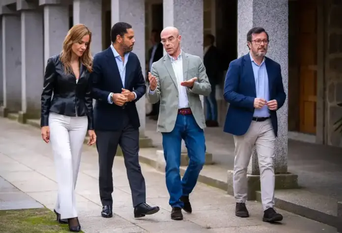 Garriga exige en El Escorial una respuesta contundente el 29N frente a las «mentiras y manipulaciones» del socialismo (1) FOTOGRAFÍA. EL ESCORIAL, 17 DE OCTUBRE DE 2026. De izquierda a derecha: la portavoz nacional de Agenda España de Vox y portavoz del Grupo Parlamentario de Vox en la Asamblea de Madrid, Isabel Pérez-Moñino-Aranda; el secretario general de Vox, número dos de esta formación verde y presidente del Grupo Parlamentario de Vox en el Parlamento de Cataluña, Ignacio Garriga Vaz de Conceiçao; el jefe de los servicios jurídicos nacionales de Vox, jefe de la Delegación de Vox en Bruselas y eurodiputado de Patriots for Europe en la Eurocámara, Jorge Buxadé Villalba; y el presidente del Comité Ejecutivo Provincial (CEP) de Vox en Madrid, diputado en la Asamblea de Madrid y portavoz nacional de Bambú 12 (sede de Vox), José Antonio Fuster Lamelas, acudiendo este sábado al acto de El Escorial. Los cuatro dirigentes de la formación verde caminan juntos en actitud de debate por un espacio abierto con columnas de piedra de la institución madrileña, coordinando la estrategia política ante la inminente cita con las urnas del 29 de noviembre. Lasvocesdelpueblo (Ñ Pueblo).